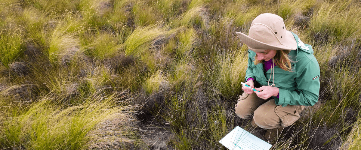 Research student in the field recording field notes 